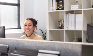 automotive staffing agency recruiter smiling at desk.