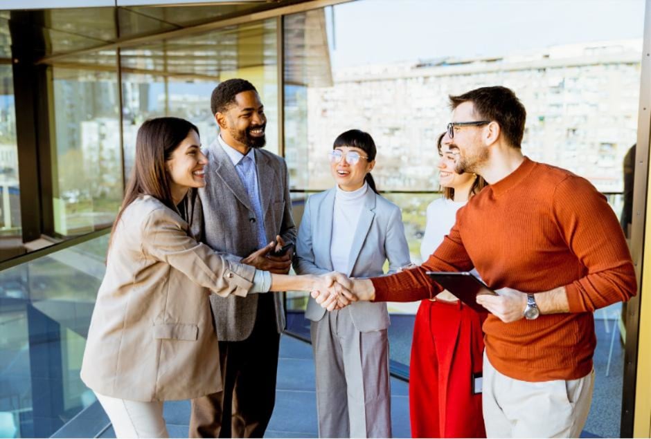 Professionals shaking hands during a business meeting, representing workforce solutions through successful hiring partnerships, talent acquisition, and team collaboration.